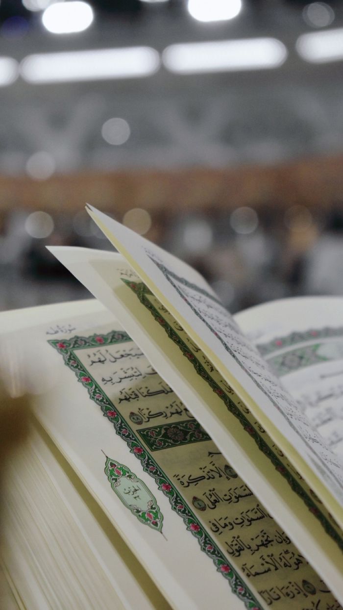 heros-img Close-up of an open Quran with Arabic text, blurred background for focus on holy scripture.